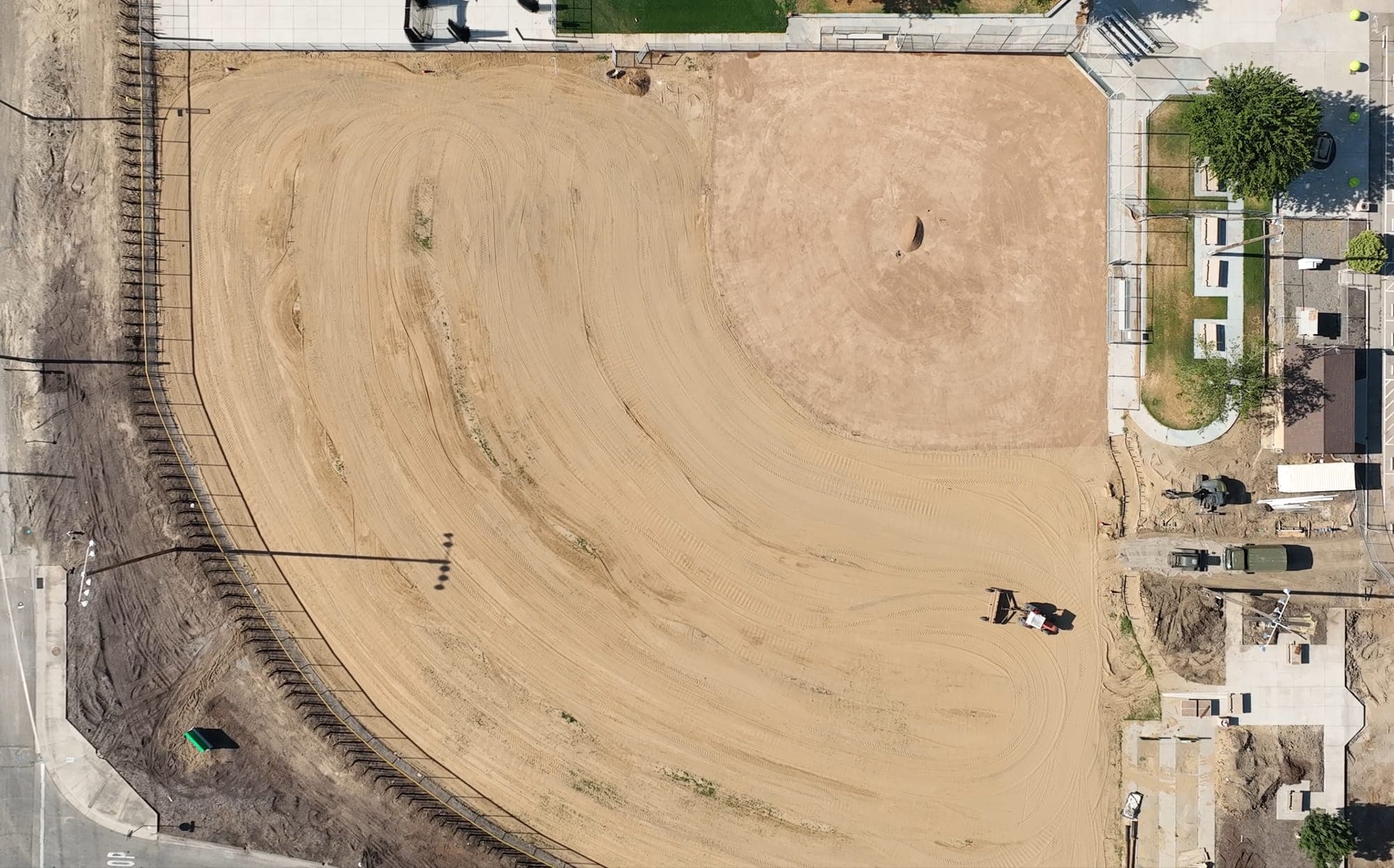 Aerial view of construction site with excavator on prepared land